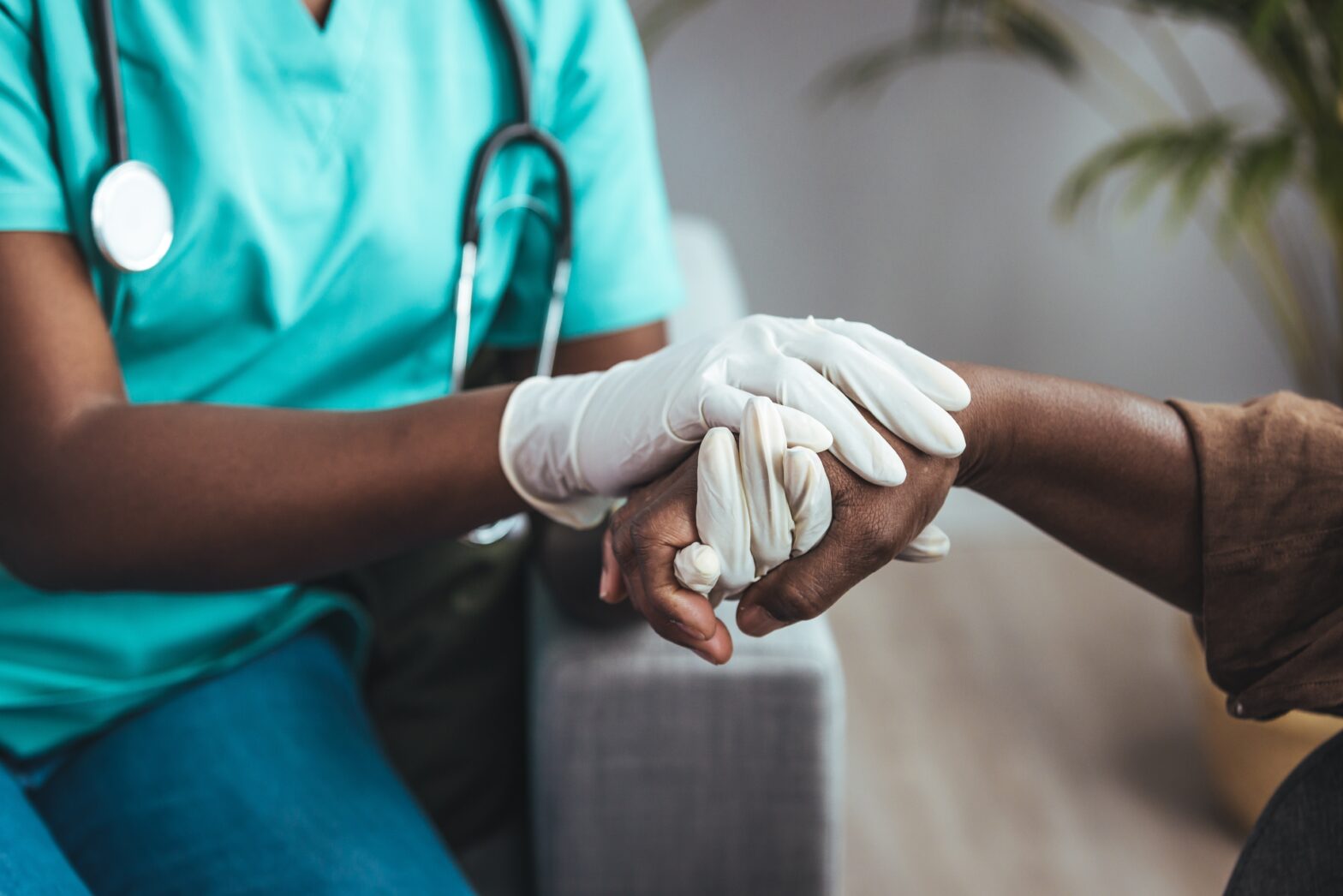 Shot of a hand being held by other hands beloning to a medical professional