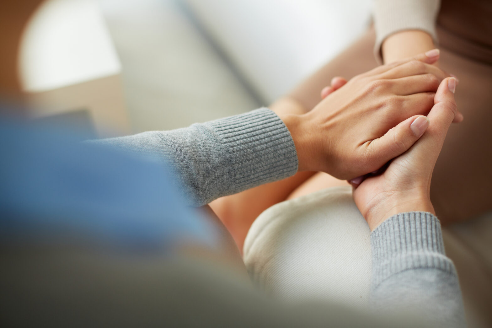 One person reaching and holding another persons hand